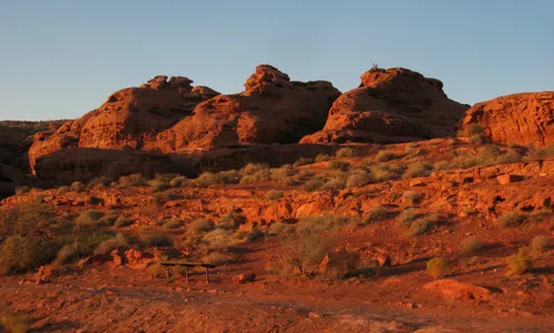 Red sandstone formations glow warm in the setting sunk