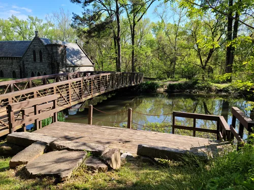 A wooden footbridge spans the water near the historic Pump House