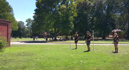 Quidditch players practice on the open green lawn