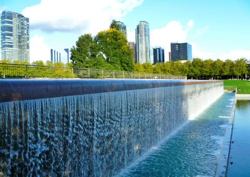 The Infinite Fountain's dramatic waterfall with Bellevue towers beyond