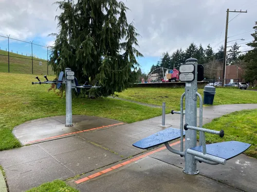 Outdoor fitness equipment stations along the park's paved trail