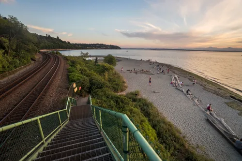 Stairs descend to Carkeek Park Beach with railroad tracks along the shore