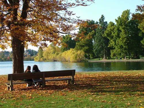 Couple on a park bench overlooking the water on an autumn afternoon