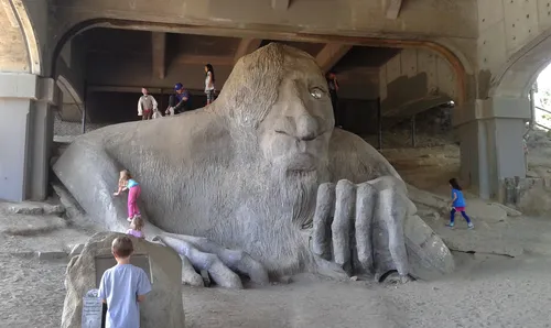 Children explore the massive concrete form of the Fremont Troll sculpture