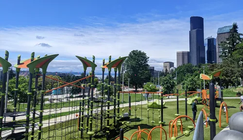 A modern playground with colorful equipment overlooks Seattle and Elliott Bay