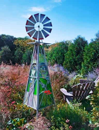Decorative windmill stands among colorful flowering plants