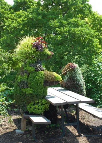 Whimsical plant creatures welcome visitors at a garden table