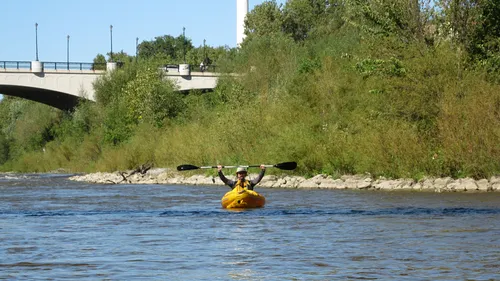 A kayaker paddles the Milwaukee River on a sunny day