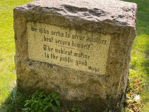 A stone marker inscribed with a quote from Virgil