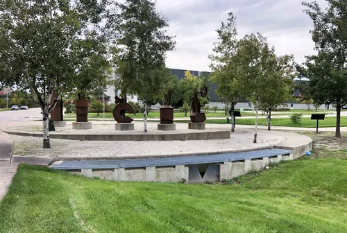 The People of the Road corten steel sculptures honor railroad workers amid park greenery