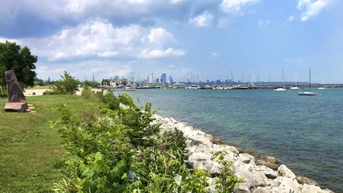 Green shores and blue waters with Milwaukee's skyline behind